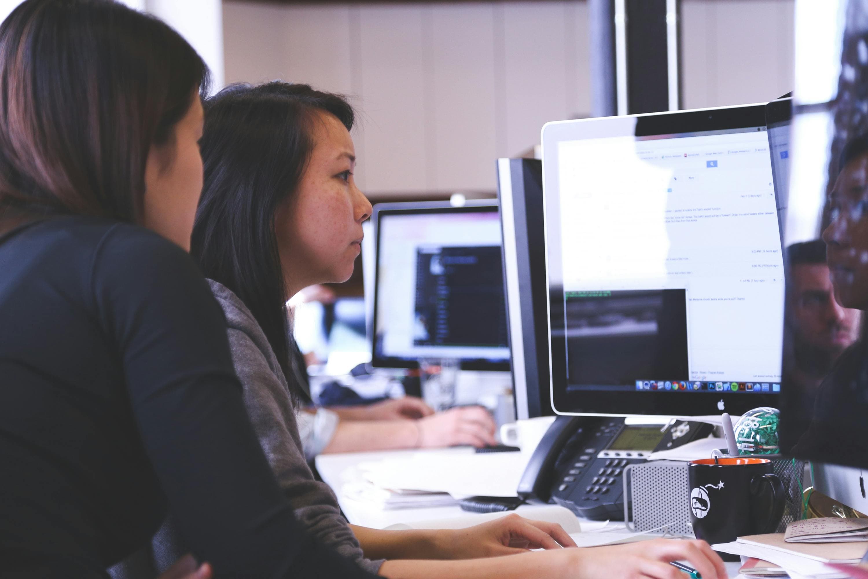 Two professionals in suits in a business office setting